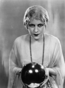 17th April 1928: Ruby Miller holding a crystal ball in a scene from the play 'The Monster' at the Strand Theatre, London. (Photo by Sasha/Getty Images)